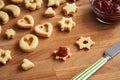 Homemade Linzer Christmas cookies are being filled with strawberry marmalade