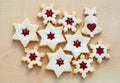 Homemade linzer cookies in a shape of snowflakes, stars and bell filled with strawberry jam Royalty Free Stock Photo