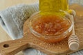 Homemade lip scrub made out of brown sugar, honey and olive oil in glass bowl on wooden chopping board - Natural beauty product Royalty Free Stock Photo