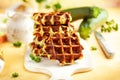 Homemade low carb zucchini waffles on white wooden board on yellow background. Concept of keto diet food