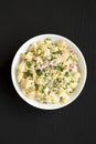 Homemade Macaroni Salad in a white bowl on a black background, top view. Flat lay, overhead, from above Royalty Free Stock Photo