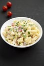 Homemade Macaroni Salad in a white bowl on a black surface, side view Royalty Free Stock Photo