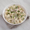 Homemade Macaroni Salad in a white bowl on a white wooden background, low angle view. Close-up Royalty Free Stock Photo