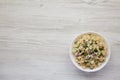 Homemade Macaroni Salad in a white bowl on a white wooden background, top view. Flat lay, overhead, from above. Space for text Royalty Free Stock Photo