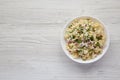 Homemade Macaroni Salad in a white bowl on a white wooden surface, top view. Flat lay, overhead, from above. Copy space Royalty Free Stock Photo