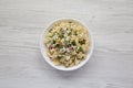 Homemade Macaroni Salad in a white bowl on a white wooden table, top view. Flat lay, overhead, from above Royalty Free Stock Photo