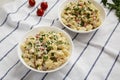 Homemade Macaroni Salad in white bowls, low angle view