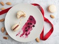 Homemade macaroons with currant filling on a gray plate. Almonds, berries of black currant and filling for cookies on a plate. Top