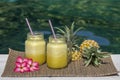 Homemade mango and pineapple smoothie made with coconut milk in two glass mug near swimming pool . Island Bali, Indonesia. Royalty Free Stock Photo