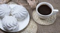 Homemade marshmallows and coffee cup. Banner with meringue cookies on  sackcloth background Royalty Free Stock Photo