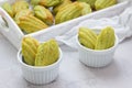 Homemade matcha green tea madeleines on the table and in wooden tray Royalty Free Stock Photo