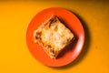 Homemade Meat lasagna on orange plate copy space