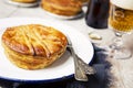 Homemade meat pie and beer on a rustic table