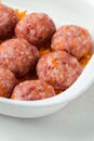 Homemade meatballs with tomato sauce, carrot and spices. Raw ground beef meatballs with rice in a white dish for baking. White Royalty Free Stock Photo