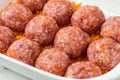 Homemade meatballs with tomato sauce, carrot and spices. Raw ground beef meatballs with rice in a white dish for baking. White Royalty Free Stock Photo