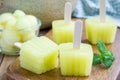 Homemade melon popsicles on a wooden background