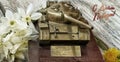 Homemade metal gift model of the tank with a memorable plate, a bouquet of spring daffodils and a Russian inscription