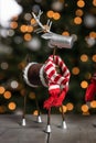 A homemade reindeer decoration in front of a Christmas tree.