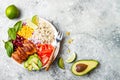 Homemade Mexican chicken burrito bowl with rice, beans, corn, tomato, avocado, spinach. Taco salad lunch bowl.