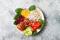 Homemade Mexican chicken burrito bowl with rice, beans, corn, tomato, avocado, spinach. Taco salad lunch bowl.