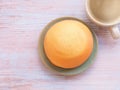 Homemade mexican vanilla bun (coffee bun) on turquoise clay round plate and coffee cup over rustic table. text. Royalty Free Stock Photo