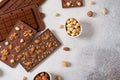 Homemade milk chocolate bars and molds. Chocolate bars, nuts, dried fruits on gray background top view, copy space. Chocolatier, Royalty Free Stock Photo