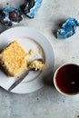 Homemade mille-feuille, puff pastry custard cream pie on white plate, chocolates, tea cup on gray background, top view Royalty Free Stock Photo