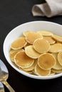 Homemade Mini Pancakes Cereal in a white bowl on a black background, side view Royalty Free Stock Photo