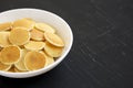 Homemade Mini Pancakes Cereal in a white bowl on a black background, side view. Copy space Royalty Free Stock Photo