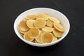 Homemade Mini Pancakes Cereal in a white bowl on a black surface, side view Royalty Free Stock Photo
