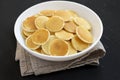 Homemade Mini Pancakes Cereal in a white bowl on a black surface, side view. Close-up Royalty Free Stock Photo
