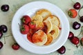 Homemade mini pancakes and fresh strawberries, cherries on an old wooden table. Top view Royalty Free Stock Photo
