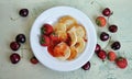 Homemade mini pancakes and fresh strawberries, cherries on an old wooden table. Top view Royalty Free Stock Photo