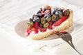 Homemade mix berry tart with fresh raspberries, blueberries, strawberries and ricotta cheese cream on white plate. Royalty Free Stock Photo