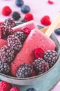 Homemade mixed berry yogurt popsicles in a bowl on pink background Royalty Free Stock Photo