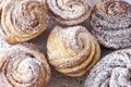 Homemade modern cruffin cake, yeast rolled cinnamon bun sprinkled powdered sugar. Copy space. Background. Close up. Top view