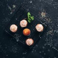 Homemade muffins glazed with colored sprinkles on a cooling rack. Black stone grunge background. Top view Royalty Free Stock Photo