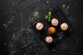 Homemade muffins glazed with colored sprinkles on a cooling rack. Black stone grunge background. View from above Royalty Free Stock Photo