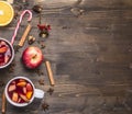 Homemade mulled wine with apple, orange, cinnamon, cloves and other ingredients have been laid out around on wooden rustic backg