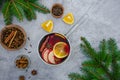 Homemade mulled wine with apple, orange, ginger, cinnamon, cardamom and star anise in a saucepan on a gray background. Royalty Free Stock Photo