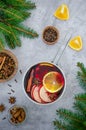 Homemade mulled wine with apple, orange, ginger, cinnamon, cardamom and star anise in a saucepan on a gray background. Royalty Free Stock Photo