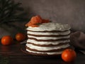 homemade multi-layered high chocolate cake with white cream and tangerines