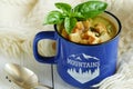 Homemade mushroom soup with cream, basil and crackers in enamel mug Royalty Free Stock Photo