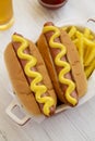 Homemade Mustard Hot Dog with French Fries on a white wooden background, high angle view Royalty Free Stock Photo