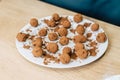 Homemade natural chocolate truffle with cacao on wooden background. Lies on a white plate. Royalty Free Stock Photo