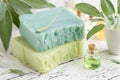 Homemade natural organic soap bars, bottle of essential sage oil and fresh green sage leaves on white table Royalty Free Stock Photo