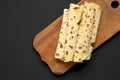 Homemade Norwegian Potato Flatbread Lefse with Butter and Sugar on a rustic wooden board on a black background, top view. Copy