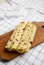 Homemade Norwegian Potato Flatbread Lefse with Butter and Sugar on a rustic wooden board on cloth, side view. Copy space