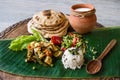Homemade nutritional vegetable ragout, rice, salad, yogurt, chapati on a banana leaf.