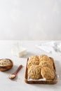 Homemade oatmeal cookies with banana, oats and nuts on a wooden tray and oats flakes on white background, side view, copy space. Royalty Free Stock Photo